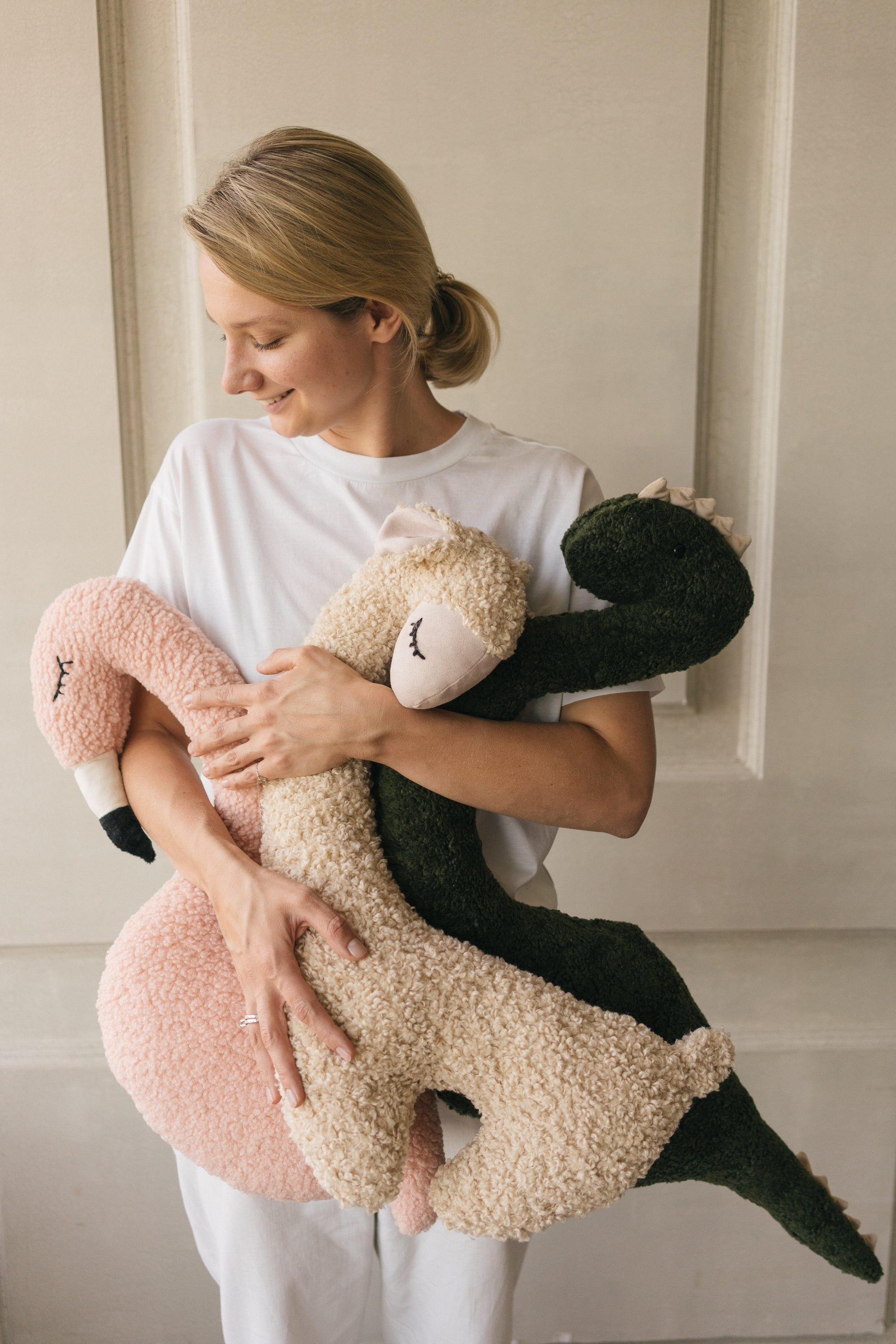 Woman holding a plush toy in a neutral setting