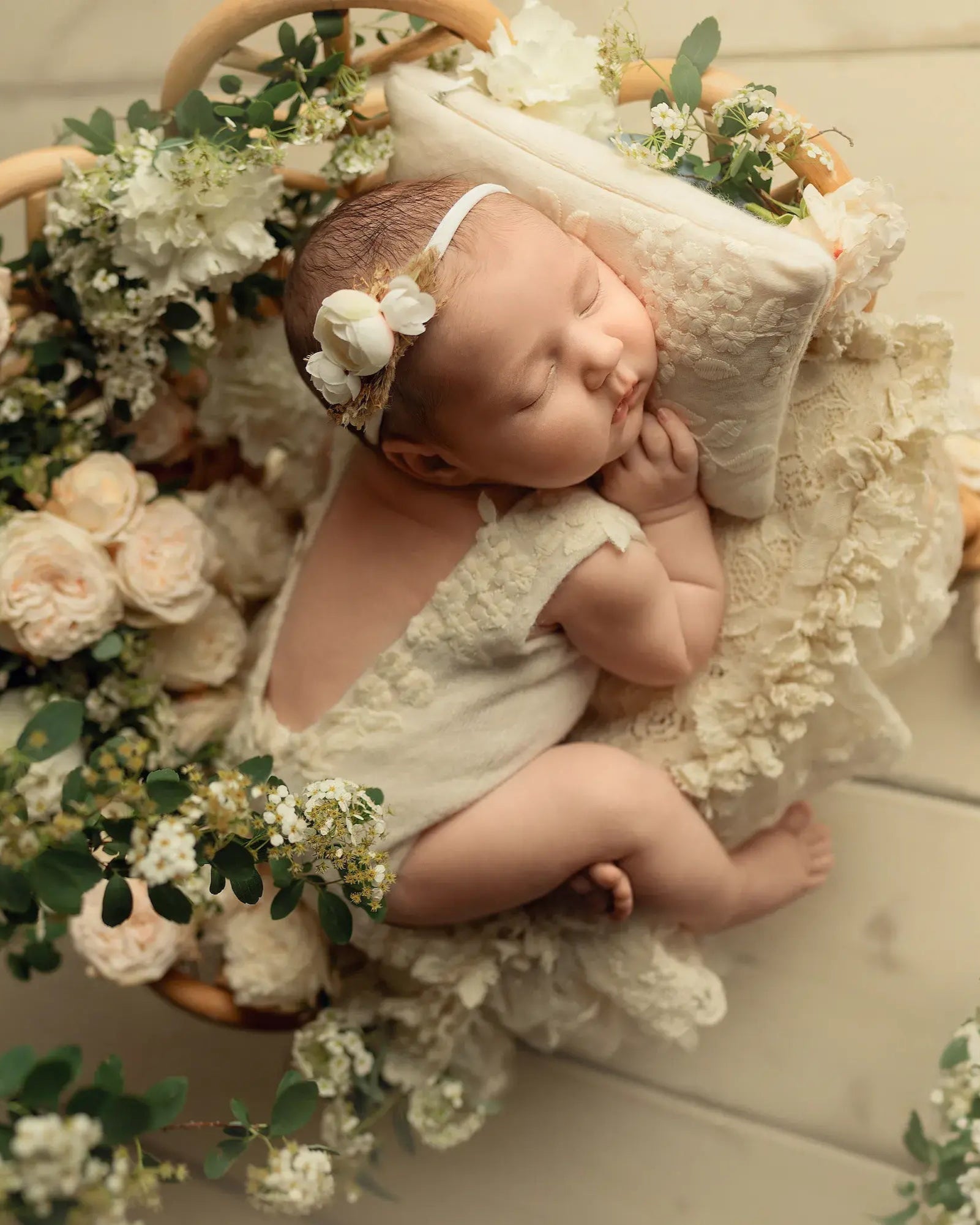 Newborn baby in a floral arrangement with a soft focus background