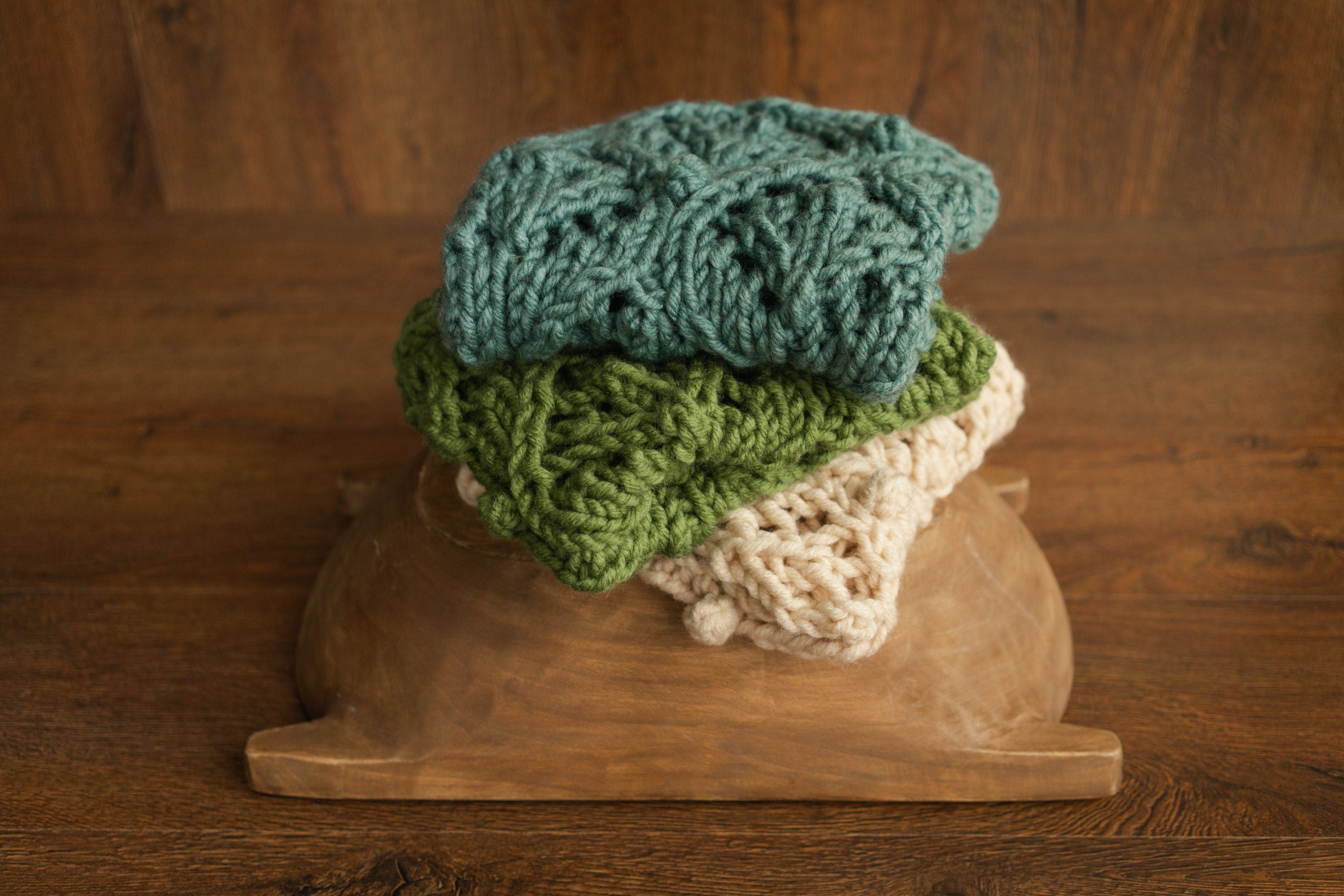 Soft hand-knitted newborn layer with tiny pom-poms — delicate wool prop ideal for baskets, wraps, or layered newborn photography setups.