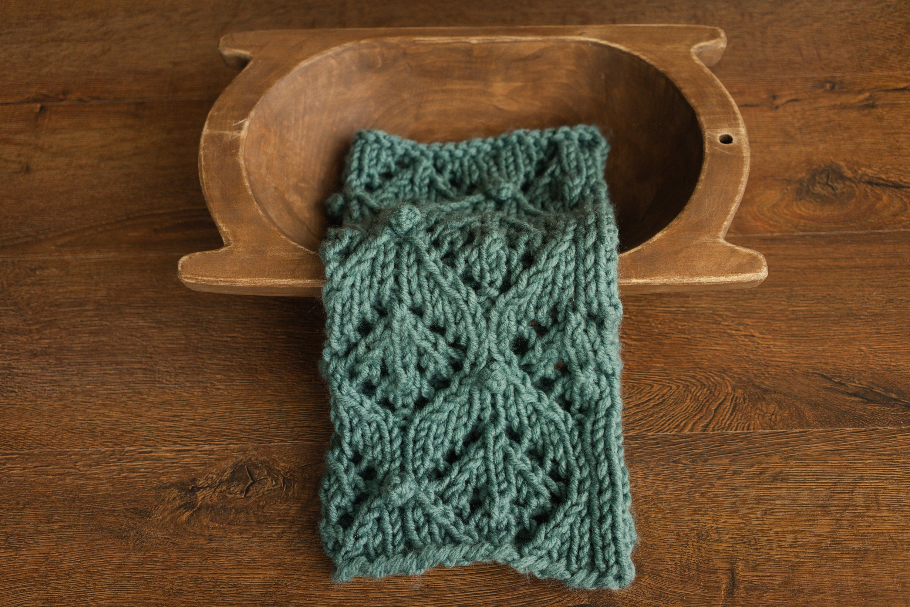 Soft hand-knitted newborn layer with tiny pom-poms — delicate wool prop ideal for baskets, wraps, or layered newborn photography setups.