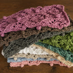 Soft hand-knitted newborn layer with tiny pom-poms — delicate wool prop ideal for baskets, wraps, or layered newborn photography setups.