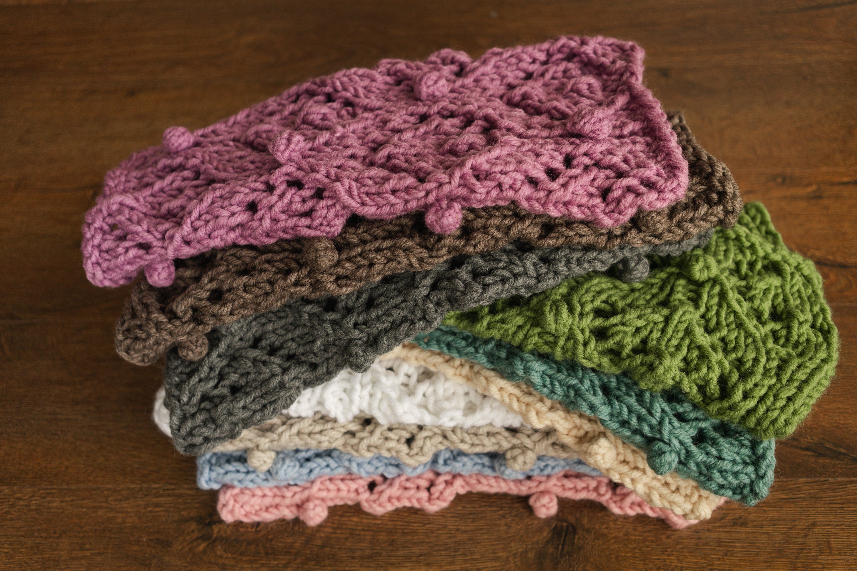 Soft hand-knitted newborn layer with tiny pom-poms — delicate wool prop ideal for baskets, wraps, or layered newborn photography setups.