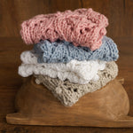 Soft hand-knitted newborn layer with tiny pom-poms — delicate wool prop ideal for baskets, wraps, or layered newborn photography setups.