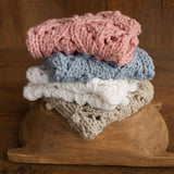 Soft hand-knitted newborn layer with tiny pom-poms — delicate wool prop ideal for baskets, wraps, or layered newborn photography setups.